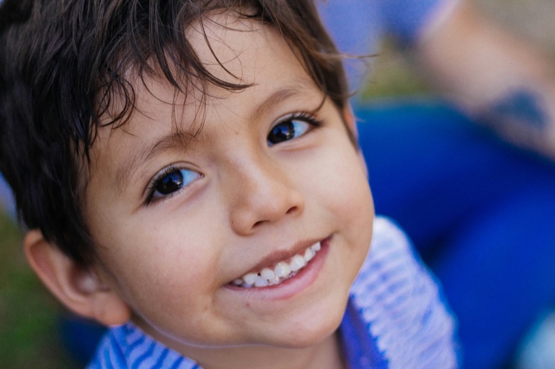 Child smiling outdoors in soft natural light